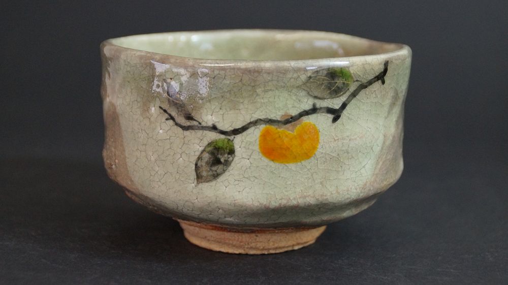 Weitere Ansicht der Chawan aus Kyoto-Keramik mit handgemaltem Kakizweig und oranger Frucht