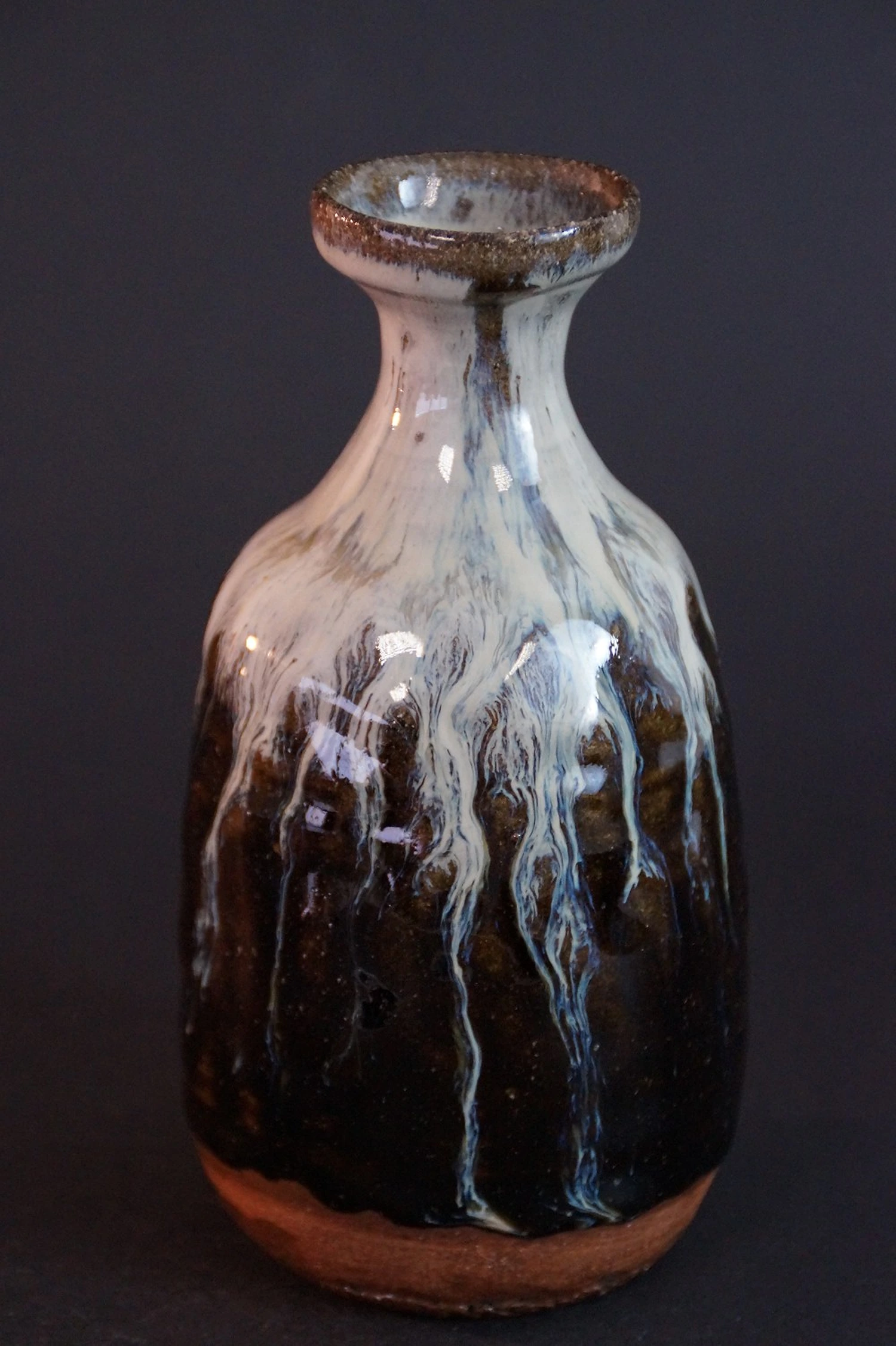 Vista frontal de la botella de sake de cerámica Karatsu torneada a mano con esmalte fluido