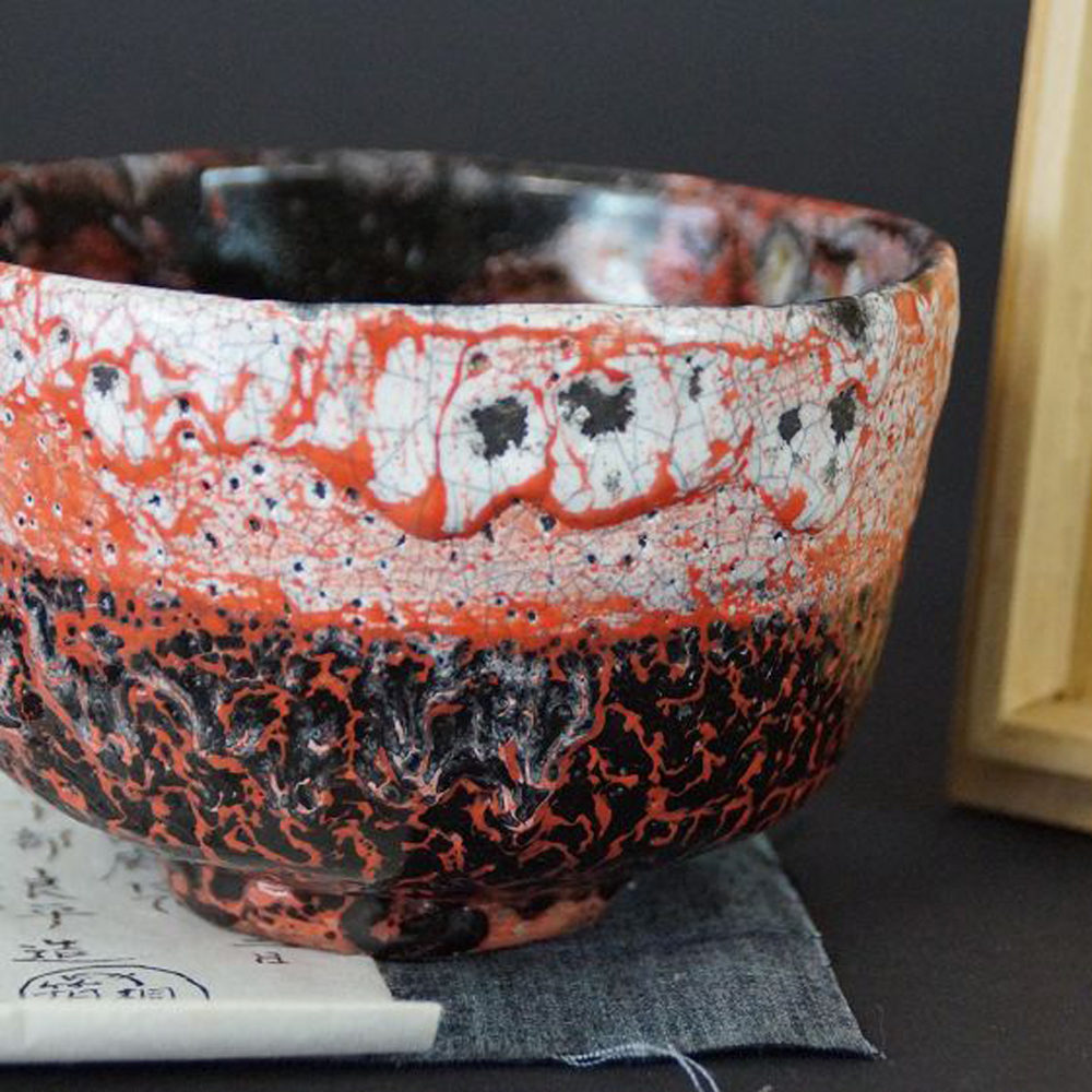 Weitere Ansicht der Chawan Teeschale aus Raku-Keramik neben dem beschrifteten Echtheitszertifikat