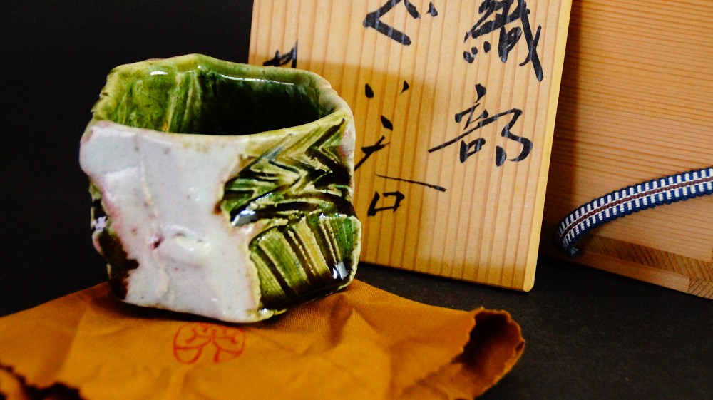 Guinomi aus Oribe-Keramik neben der beschrifteten Aufbewahrungsbox von Kawachi Hidetoshi