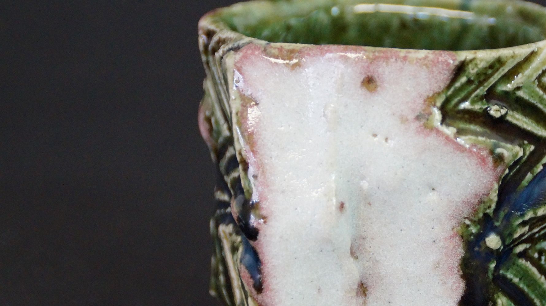 Nahaufnahme des Randes mit rosa-gruenem Glasurverlauf der Guinomi Sake-Schale aus Oribe-Keramik