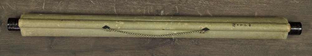Zusammengerolltes und mit Kordel verschnuertes Kakemono mit Jikusaki aus Holz