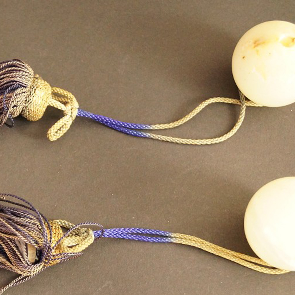 Zwei helle Natursteinkugeln mit lila-goldenen Seidenquasten Set Nahaufnahme Vorschau