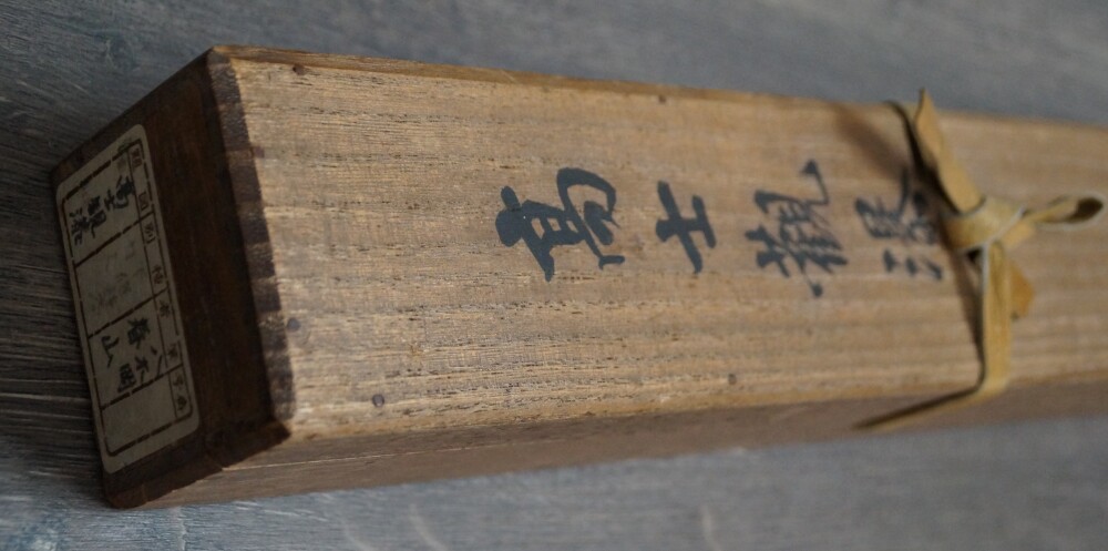 Nahaufnahme der Aufbewahrungsbox mit der Tuschebeschriftung Koushi des Kakemono Begegnung am Rand des Wasserfalls von Yagioka Shunzan