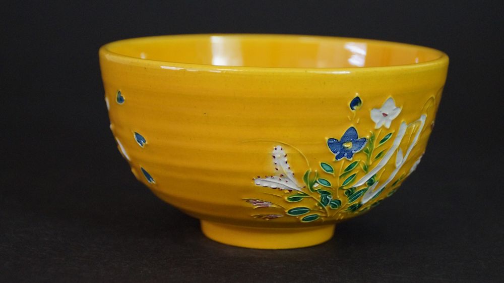 Weitere Ansicht der Chawan aus Kyoto-Keramik mit blau-weissen Blueten und gruenen Blaettern