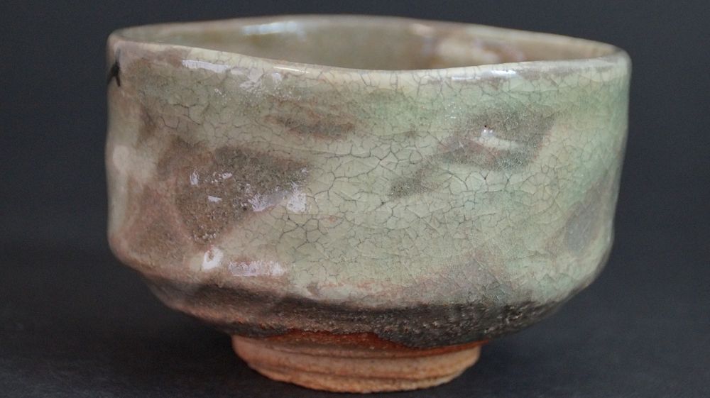 Rueckseite der Chawan aus Kyoto-Keramik mit craquelierter, gruenlich-brauner Glasur