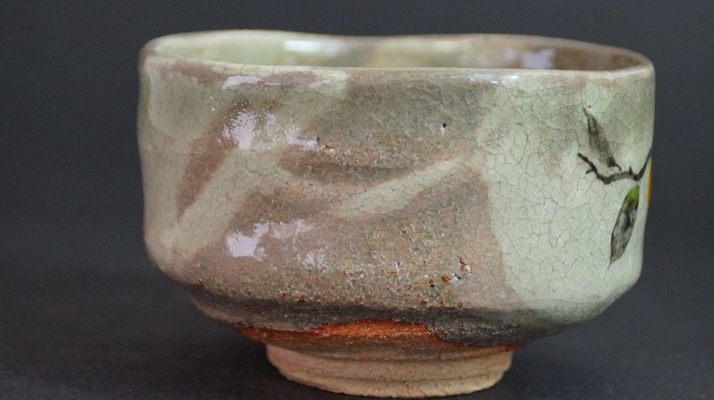 Weitere Ansicht der Chawan aus Kyoto-Keramik mit Uebergang von der Rueckseite zum Kakizweigmotiv
