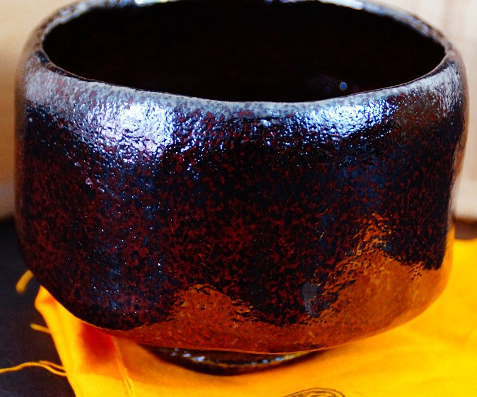 Chawan aus Raku-Keramik von Shoraku Sasaki mit rotbraun-schwarz melierter Glasur vor der Aufbewahrungsbox