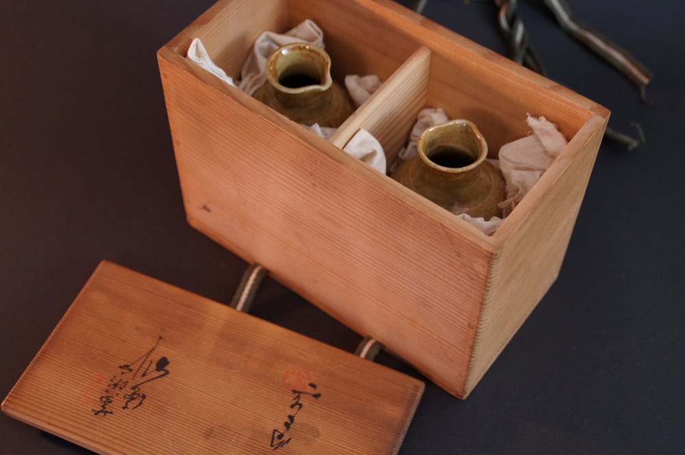 Beide Sake Flaschen eingebettet in den unterteilten Faechern der Aufbewahrungsbox