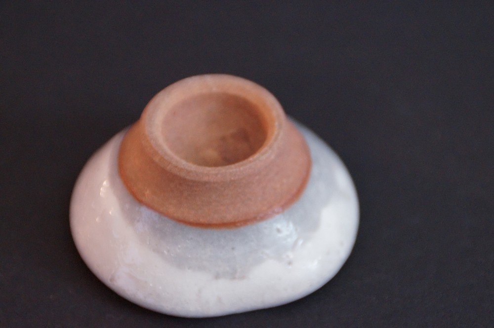Primo piano del piede non smaltato con ceramica rossastra