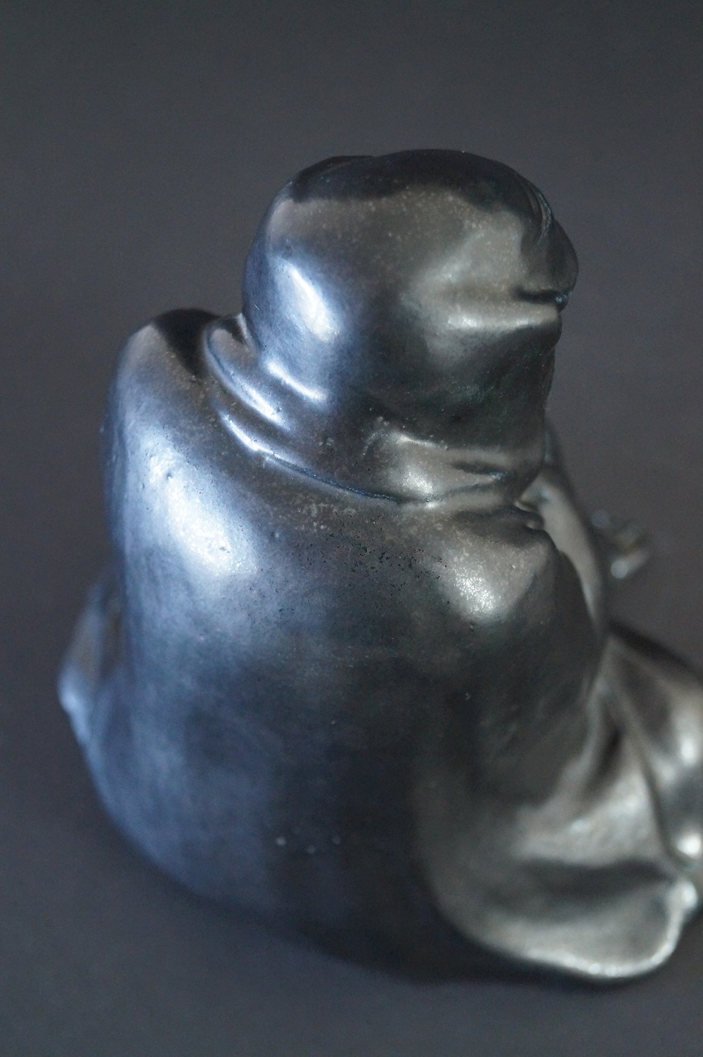 Figura de Bodhidharma Daruma de porcelana negra primer plano de la capucha
