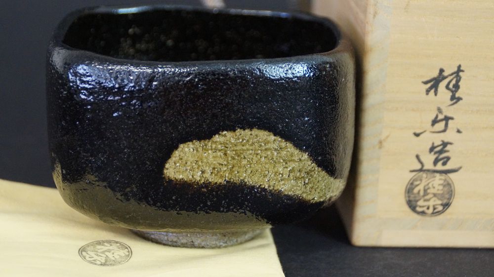 Chawan aus Raku-Keramik neben der signierten Aufbewahrungsbox mit Kuenstlersiegel