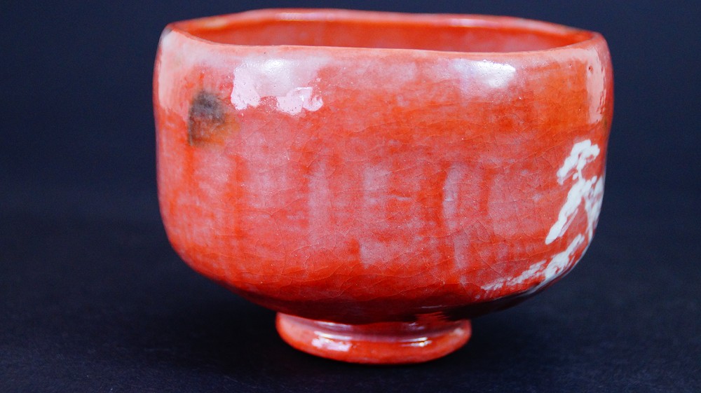 Weitere Seitenansicht der Chawan aus Raku-Keramik von Waraku Kawasaki mit dem weiss gemalten Motiv am Lippenrand