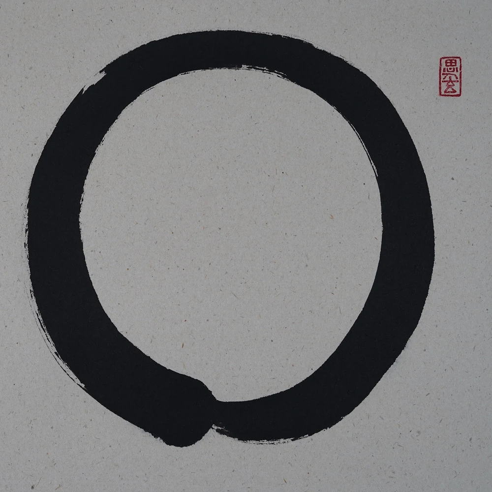 Ensō in kräftiger schwarzer Tusche mit rotem Siegel
