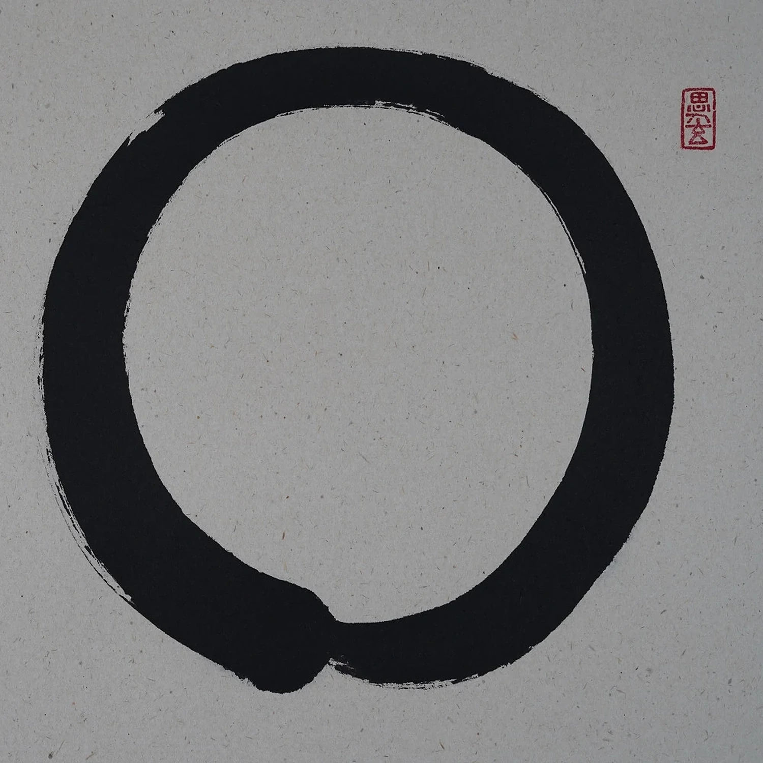 Ensō in kräftiger schwarzer Tusche mit rotem Siegel