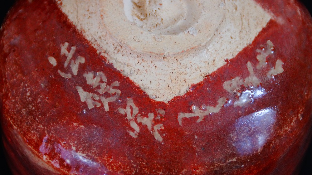 Primer plano de la base del chawan con firma de Sairi Hotoku aplicada en escritura de barbotina blanca