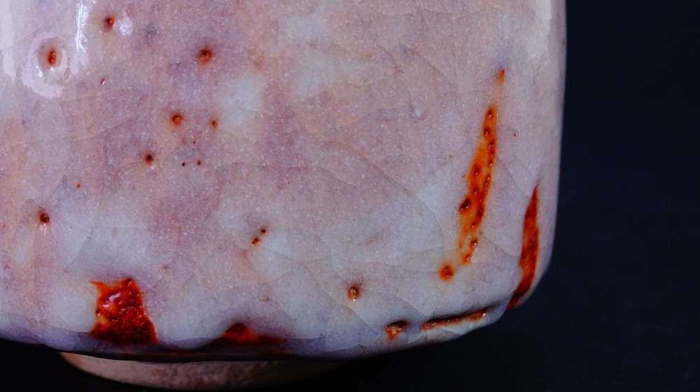 Nahaufnahme der craquelierten lachsfarbenen Glasur mit roten Feuerspuren der Chawan aus Shino-Keramik von Masayoshi Kato