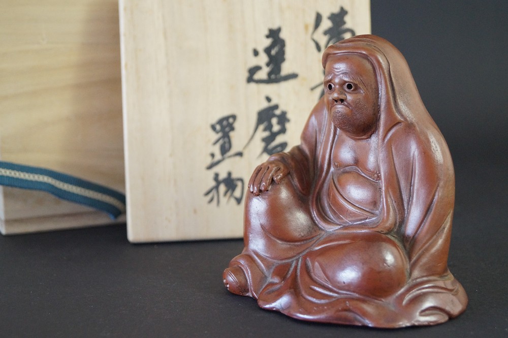 Figura de Bodhidharma vista frontal con caja de conservación 1