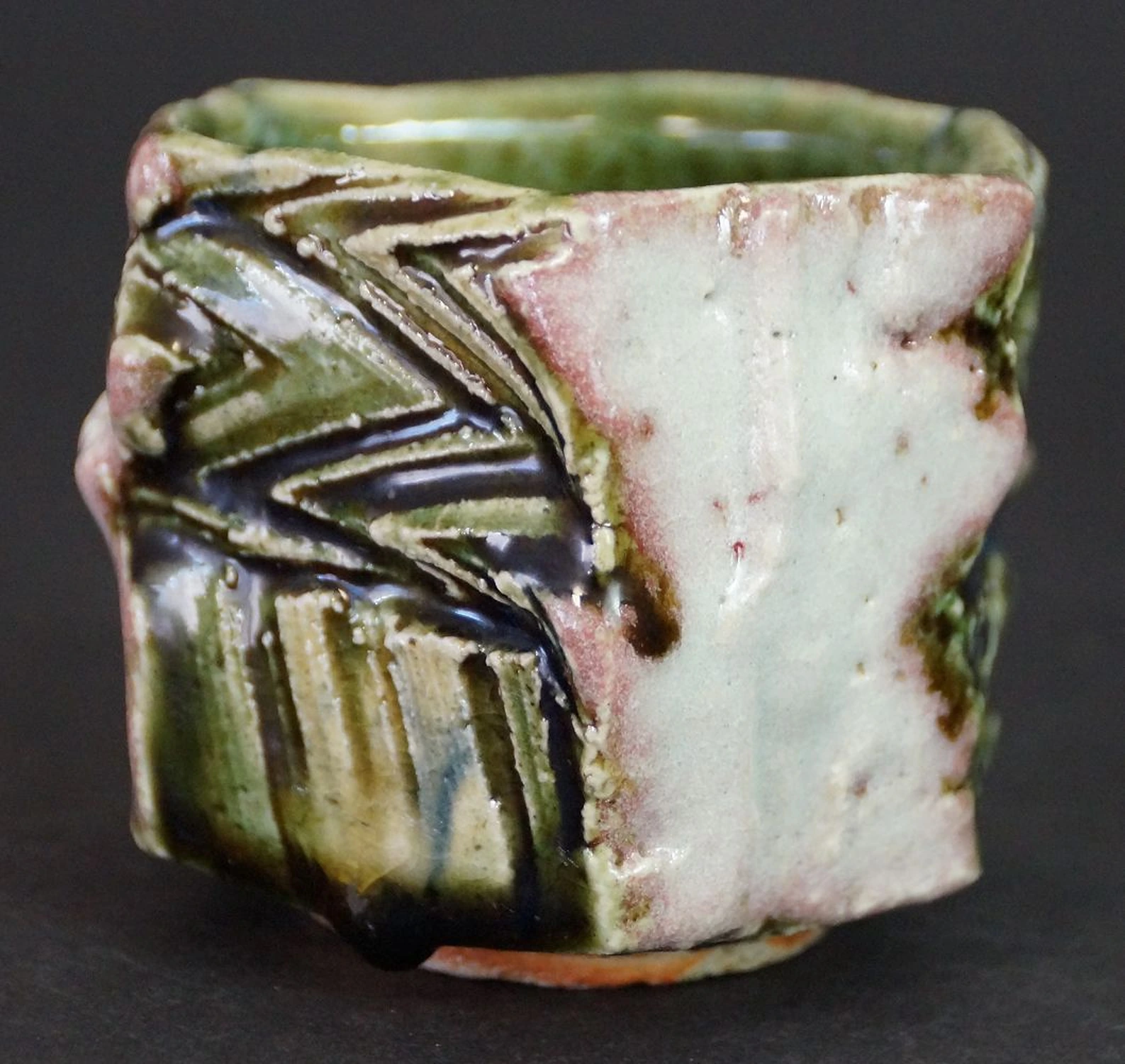 Otra vista de la copa de sake guinomi de cerámica Oribe con patrón de zigzag texturizado en verde y azul oscuro