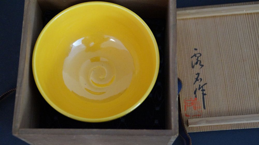 Chawan aus Kyoto-Keramik in der geoeffneten Aufbewahrungsbox neben dem signierten Kastendeckel
