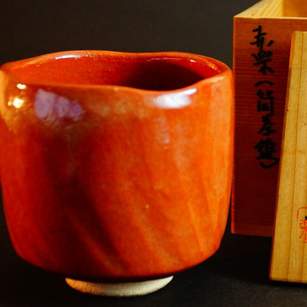 Chawan aus rot glasierter Raku-Keramik von Seiraku vor der Aufbewahrungsbox