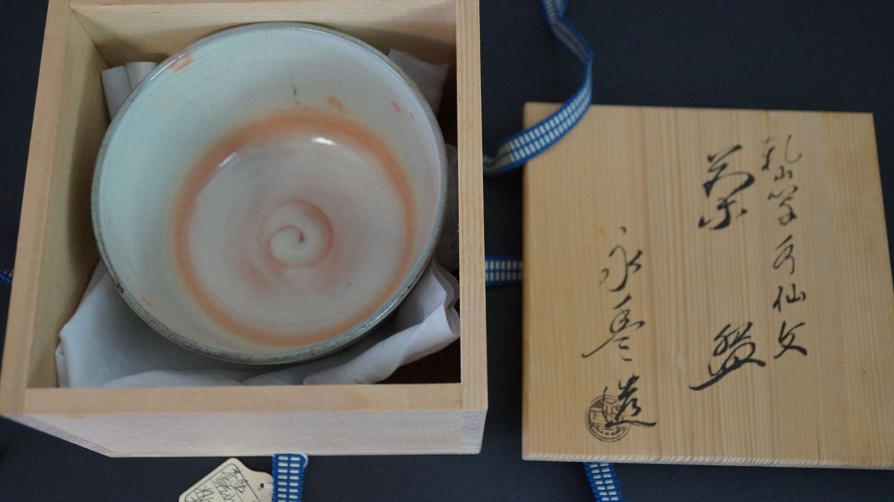 Chawan Teeschale in der geoeffneten Aufbewahrungsbox neben dem beschrifteten Kastendeckel