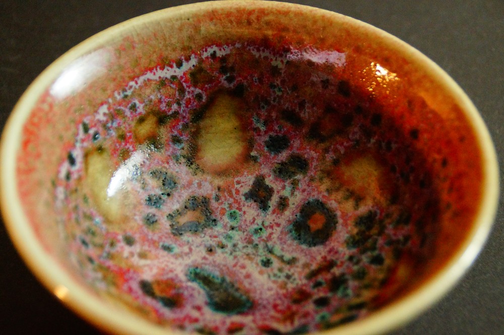 Weitere Nahaufnahme der bunt gesprenkelten Glasur im Inneren des Chawan