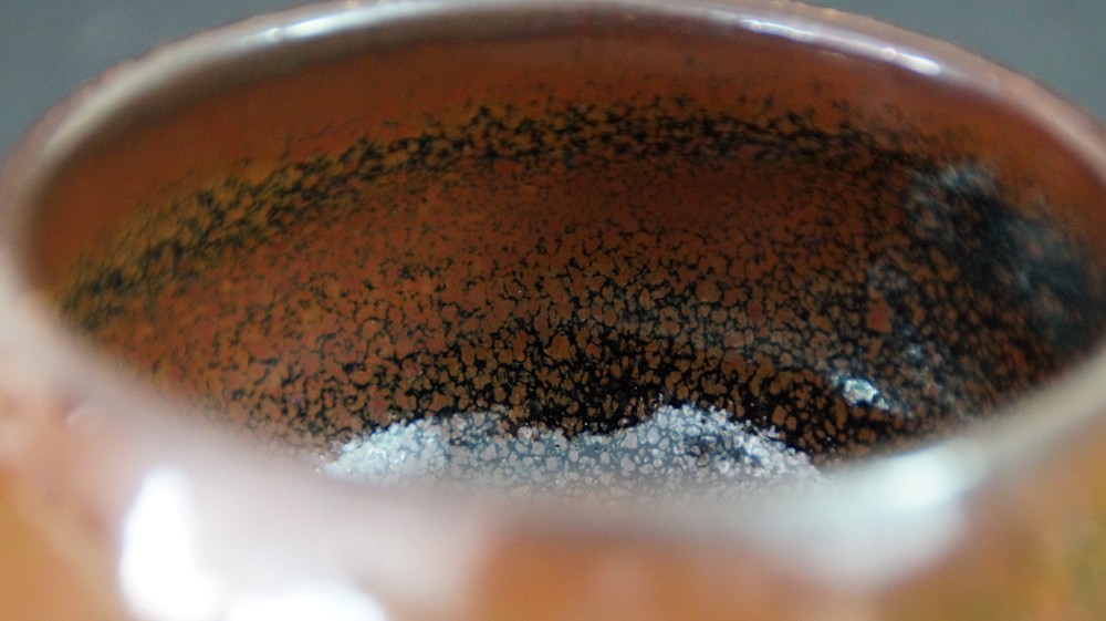 Nahaufnahme der gesprenkelten Tenmoku-Glasur am Innenrand des Chawan von Kurokawa Seisetsu