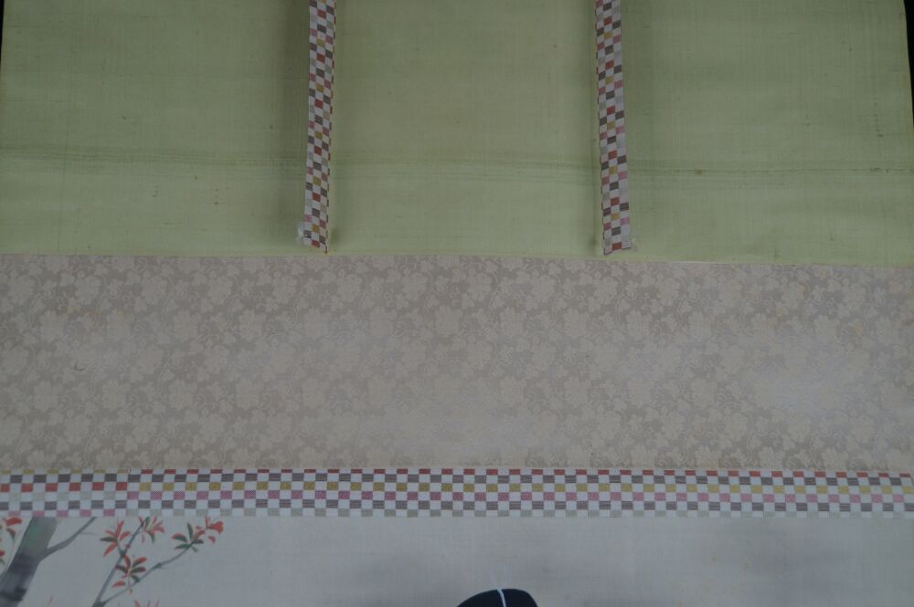 Vista dettagliata del montaggio in seta con seta verde chiaro, nastri a motivo a quadri e broccato beige del kakemono dama in kimono presso lo stagno del giardino