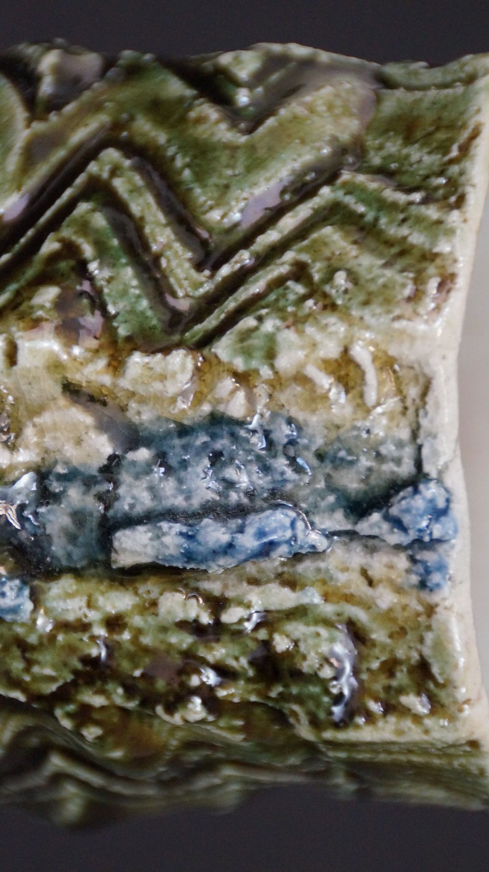 Extreme Nahaufnahme des geritzten Zickzackmusters mit blauem Glasurakzent der Yunomi Tee-Schale aus Oribe-Keramik