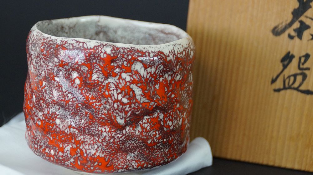 Akashin-yaki-Teeschale (Chawan) von Matsuda Kizan mit charakteristischer rot-weißer Glasur, Detailansicht.