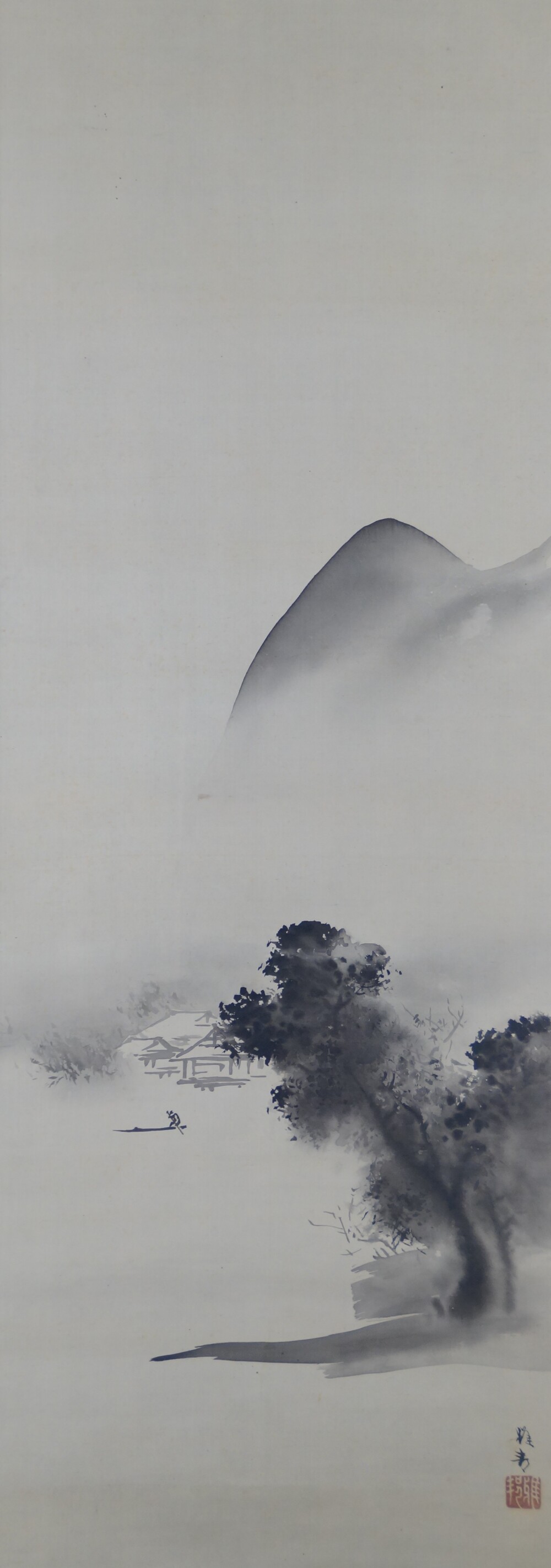 Mist-covered mountain with house on the shore and lone fishing boat in the hanging scroll House in the Mist on a Mountain Slope by Hashimoto Gaho with artist's signature and red seal
