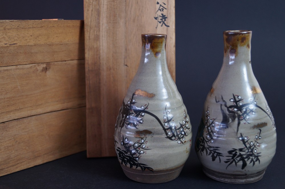 The two sake bottles next to the signed storage box inscribed Kutani-yaki