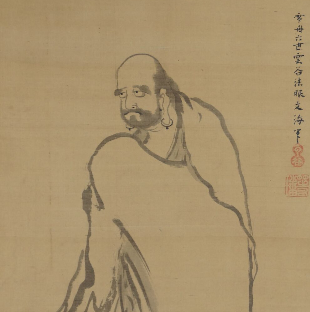 Nahaufnahme des Gesichts von Bodhidharma mit Ohrringen und Inschrift im Kakemono Bodhidharma auf dem Weg
