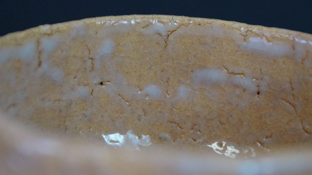 Primo piano dello smalto interno craquelé della chawan in ceramica di Hagi