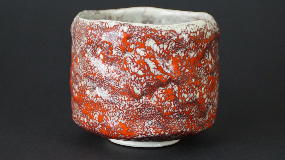Weitere Ansicht der Chawan Teeschale aus Minoh-Keramik mit netzartig craquelierter rot-weisser Glasur