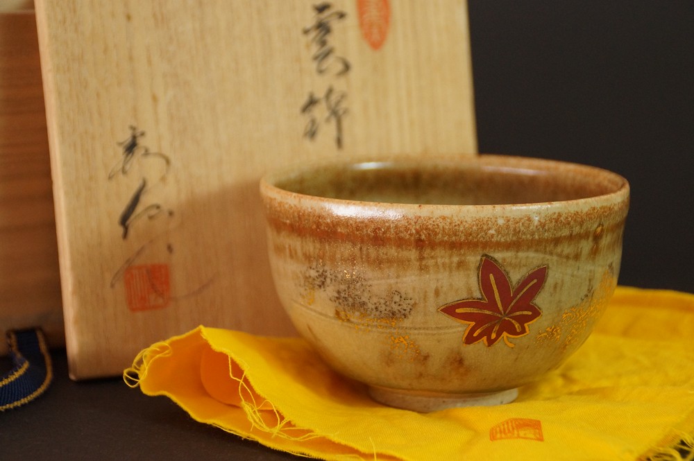 Chawan mit rotem Ahornblatt-Motiv vor der beschrifteten Aufbewahrungsbox