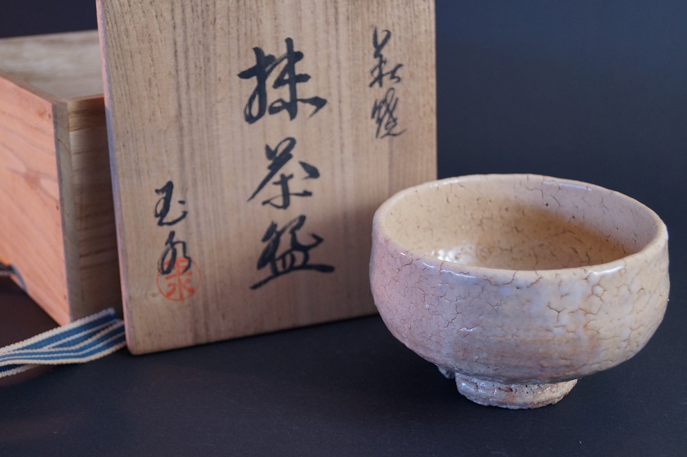 Die Teeschale vor der Aufbewahrungsbox mit der Kalligrafie Matcha-Chawan und rotem Siegel