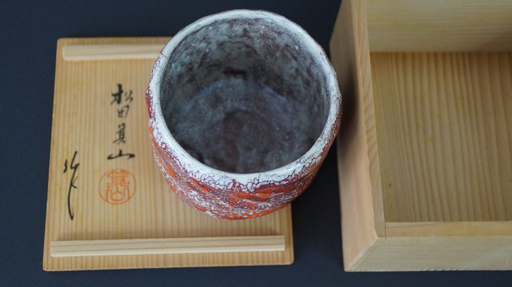 Chawan Teeschale auf dem signierten Kastendeckel von Matsuda Kizan neben der geoeffneten Aufbewahrungsbox