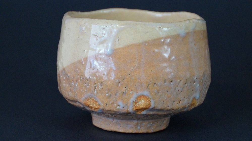 Weitere Ansicht der Chawan Teeschale aus Raku-Keramik mit cremefarbener und ockerfarbener Glasur