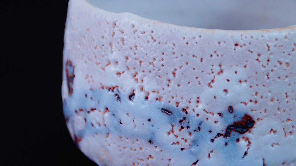 Weitere Nahaufnahme der Glasur mit blaugrauem Aschebereich und roten Feuerspuren der Chawan aus Shino-Keramik von Jyuzo Sato