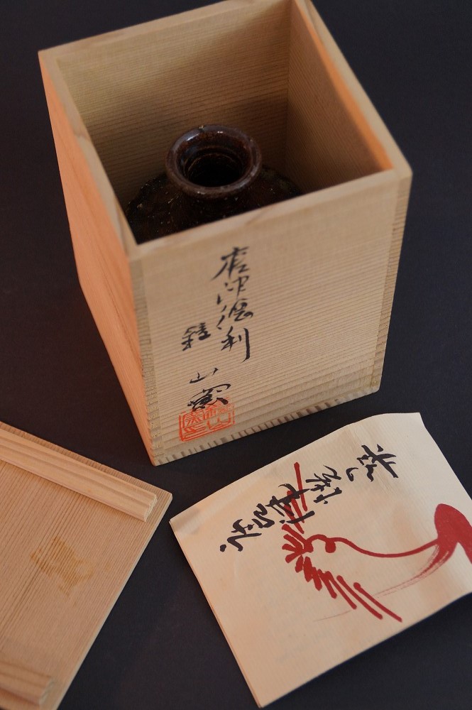 Nahaufnahme des Boxdeckels mit der Aufschrift Karatsu Tokkuri und rotem Siegel
