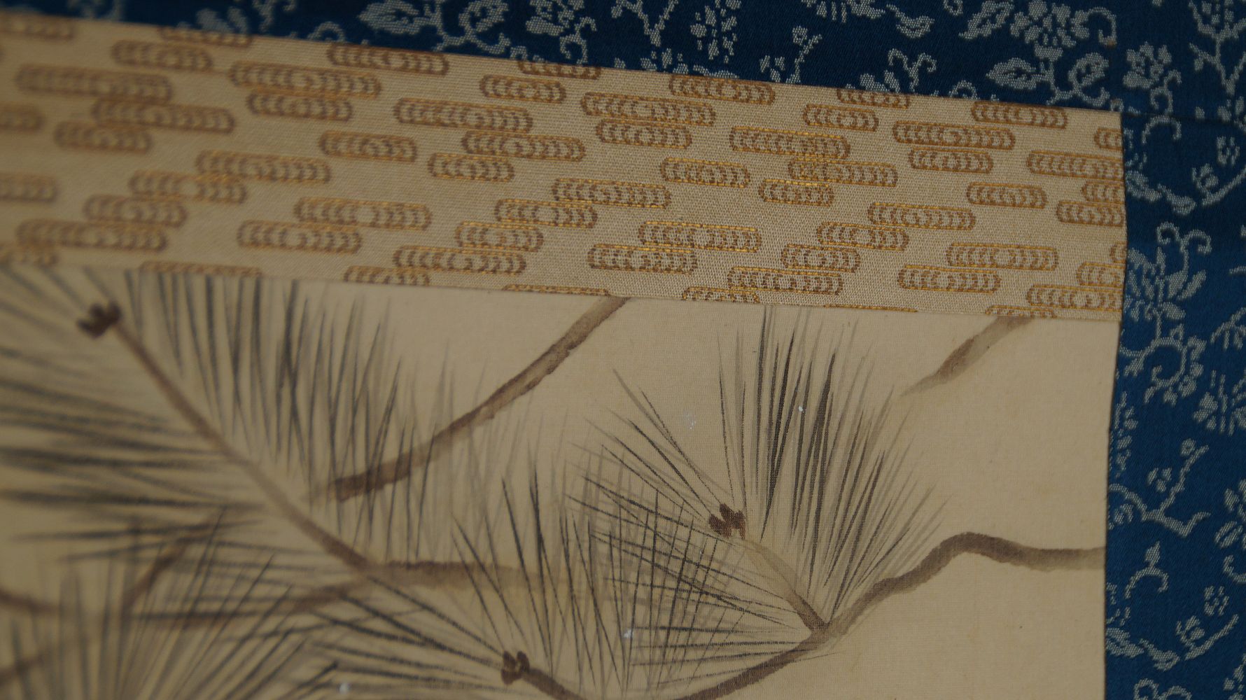 Detailansicht der blauen Brokatmontierung mit Blumenmuster am oberen Bildrand des Kakemono Karpfen im aufgewuehlten Wasserfall