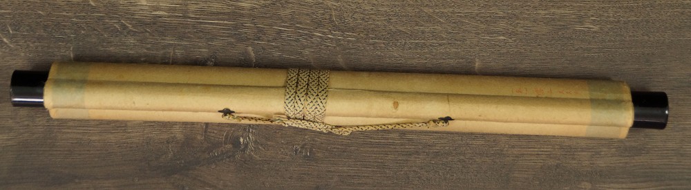 Zusammengerolltes und mit Kordel verschnuertes Kakemono mit Jikusaki aus Holz