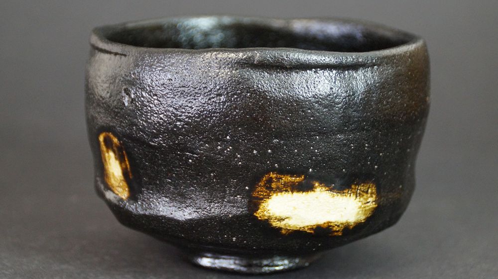 Otra vista del chawan de cerámica Raku con esmalte negro y dos manchas de esmalte dorado