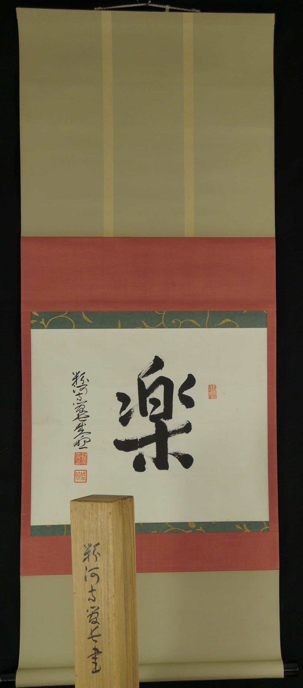 Gesamtansicht des haengenden Kakemono mit dem Schriftzeichen Raku und Aufbewahrungsbox