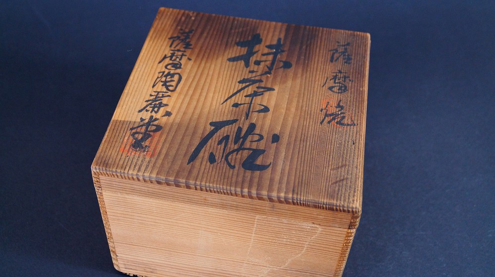 Geschlossene Aufbewahrungsbox der Chawan aus Satsuma-Keramik von Gyokusen Nozaki mit der Tuschebeschriftung Satsuma-yaki Matcha-Chawan und rotem Siegel