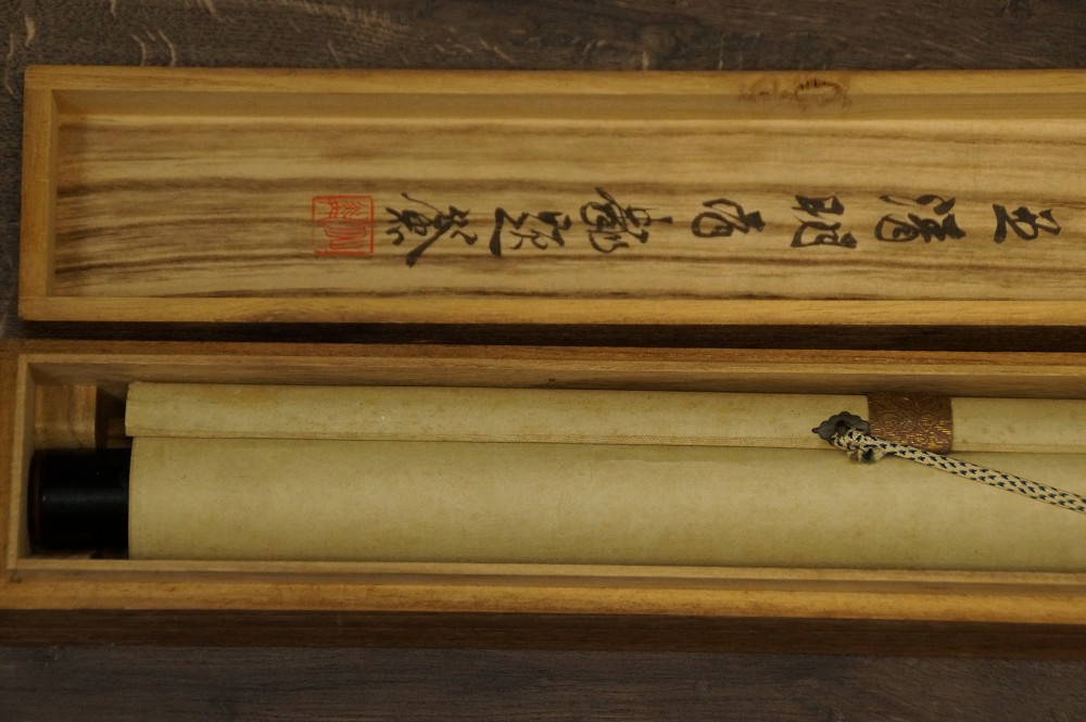 Zusammengerolltes Kakemono in der beschrifteten Aufbewahrungsbox mit Kordel