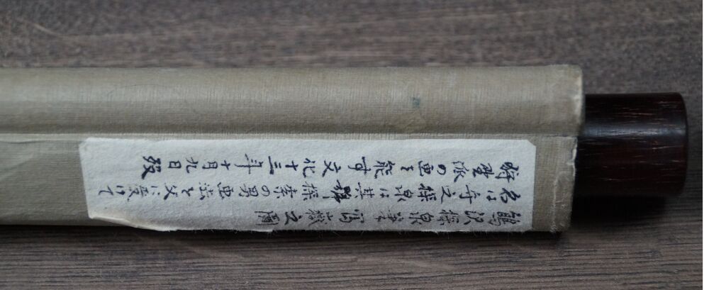Vista dettagliata dell'iscrizione sull'involucro del kakemono Fuji tra le altezze avvolte dalle nuvole
