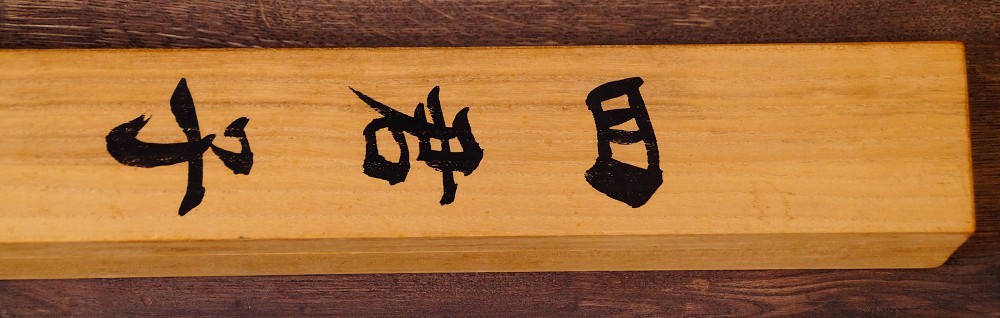 Nahaufnahme der Tuschebeschriftung auf der Seite der Aufbewahrungsbox des Kakemono Die Vier Edlen Pflanzen von Endo Keizo